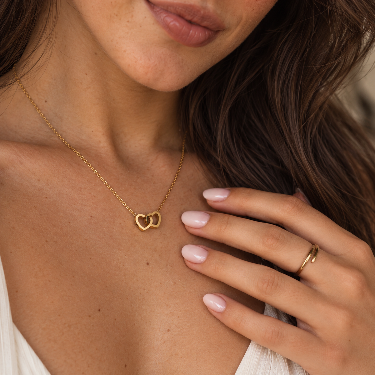 The heart necklace worn to show its size and chain length